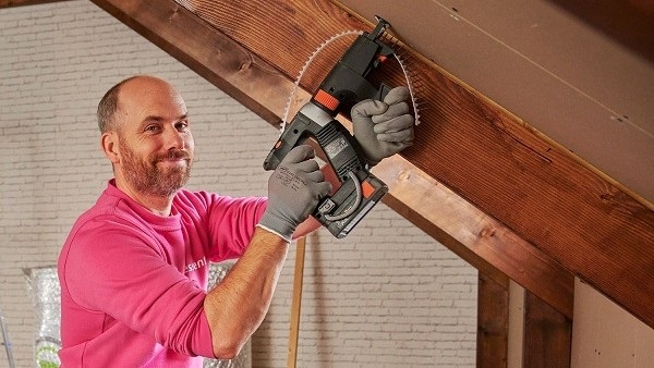 Monteur verwerkt isolatie in het dak van een woning