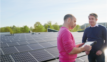 Man op dak met documenten – voorbereiding of inspectie bij gebouwonderhoud.