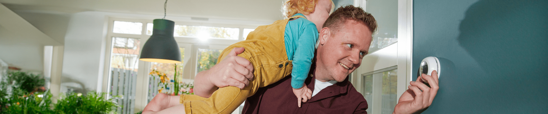 Man met kind draait aan thermostaat 