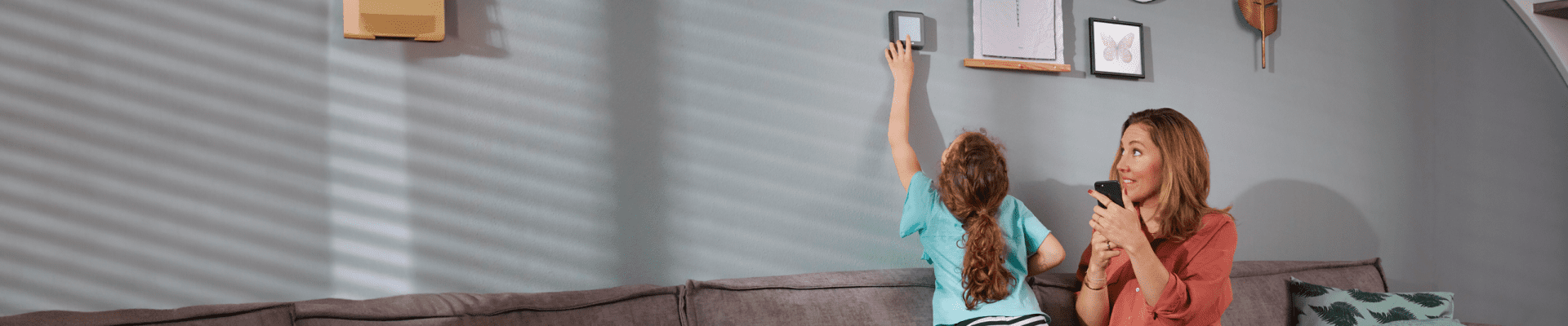 Moeder met dochter op de bank kijken naar de thermostaat