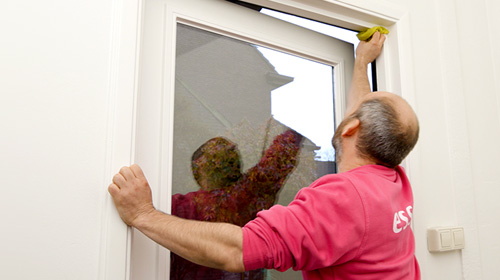Foto: Freek maakt met een doekje met schoonmaakmiddel het kozijn schoon