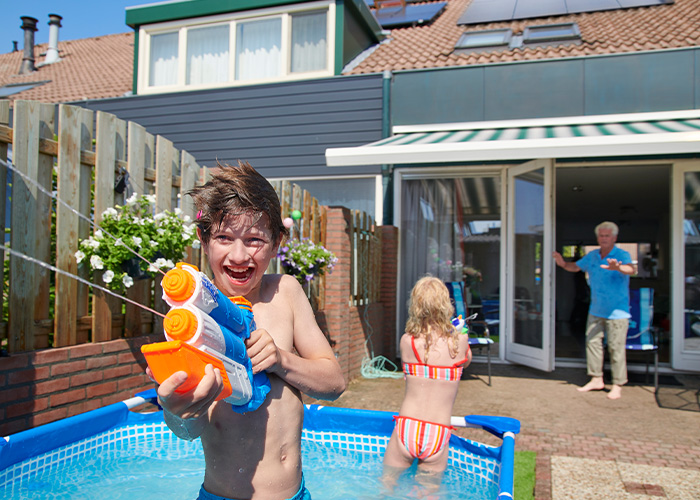 Kinderen spelen met waterpistolen in de tuin