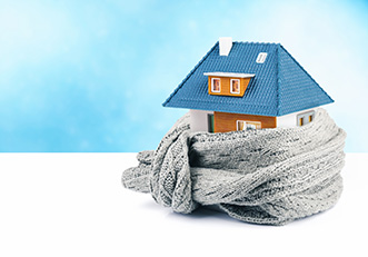 Warm huis met sjaal als symbool voor lager gemiddeld gasverbruik door goede isolatie.