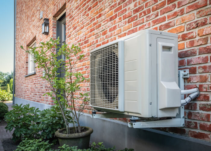Buitenunit van warmtepomp aan buitenmuur