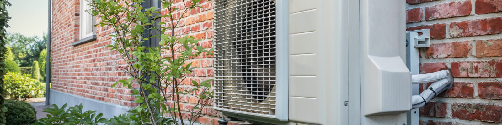 Buitenunit van een warmtepomp aan buitenmuur