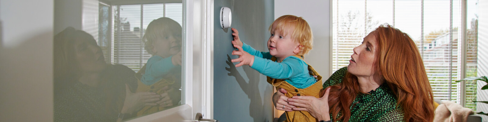 Foto van vrouw en kind bij thermostaat