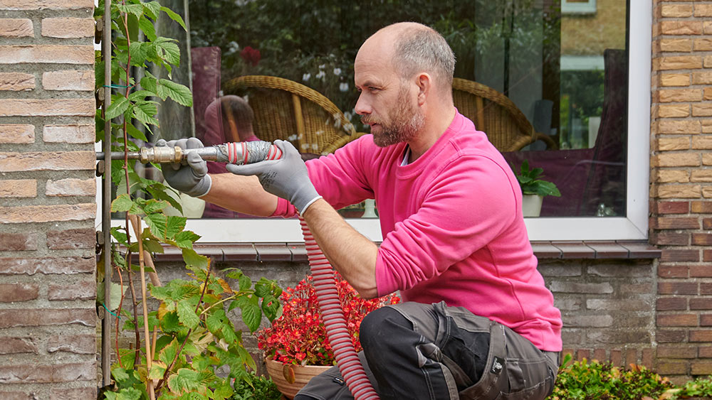 Medewerker van Essent isoleert woning  dankzij spouwmuur isolatie om energie te besparen