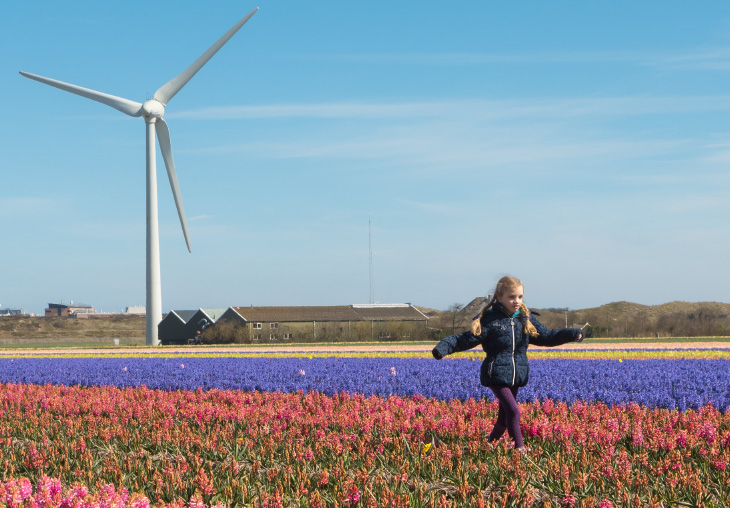 Essent stroom is 100% groen, meisje dat loopt langs windmolens