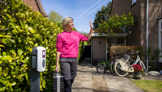 mevrouw staat op oprit naast laadpaal voor zpp'ers