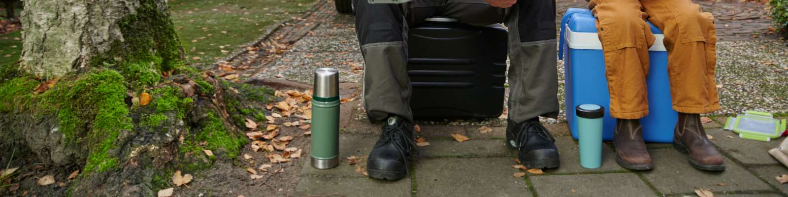 Freek en dochter houden pauze zittend op koelbox met thermoskan