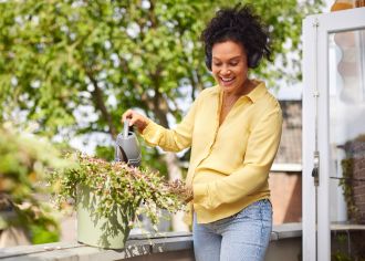 vrouw met gieter water plant