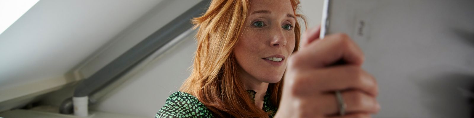 dame leest instructies op zolder met een schuin dak