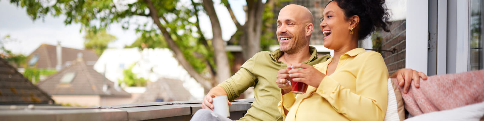 zwangere vrouw drink thee op balkon