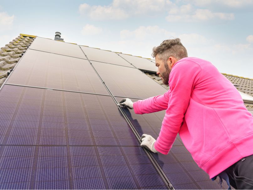 Monteur legt zonnepanelen op dak