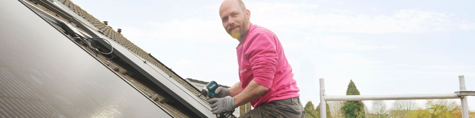 man legt zonnepanelen