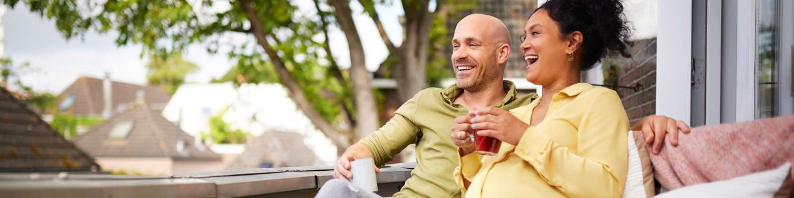 Lachend stel drinkt thee op balkon