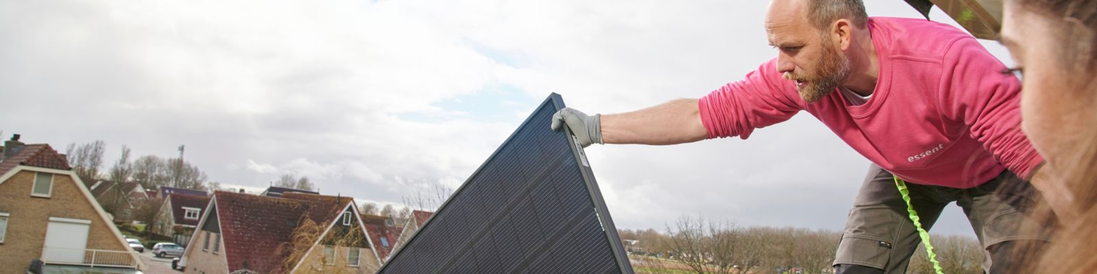 man bevestigt zonnepaneel op dak