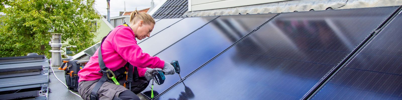 vrouw legt zonnepanelen op dakkapel