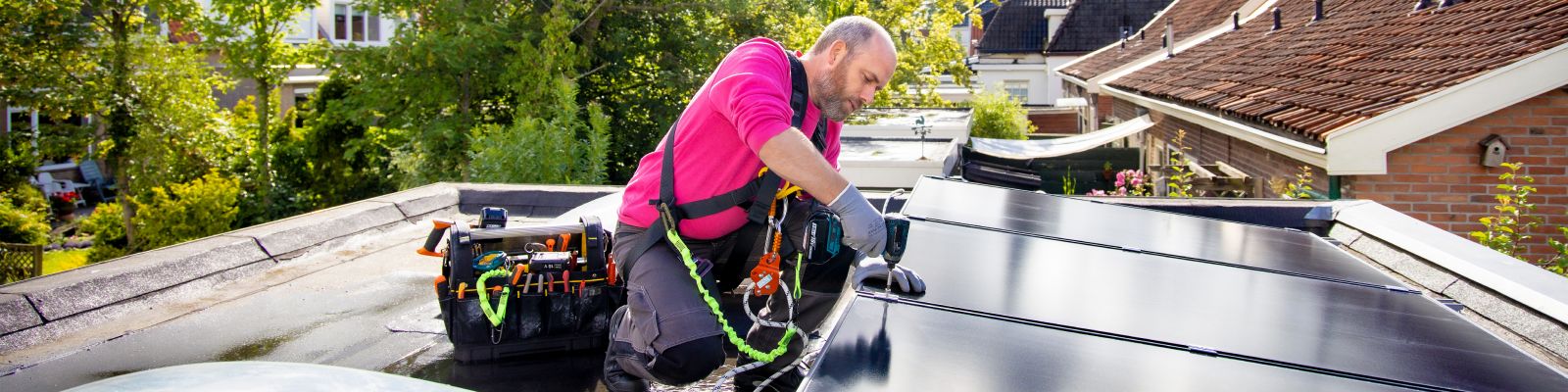 man legt zonnepanelen op schuur