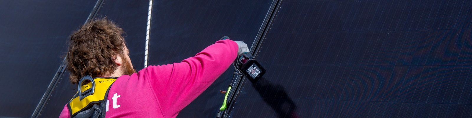 man is bezig met zonnepanelen