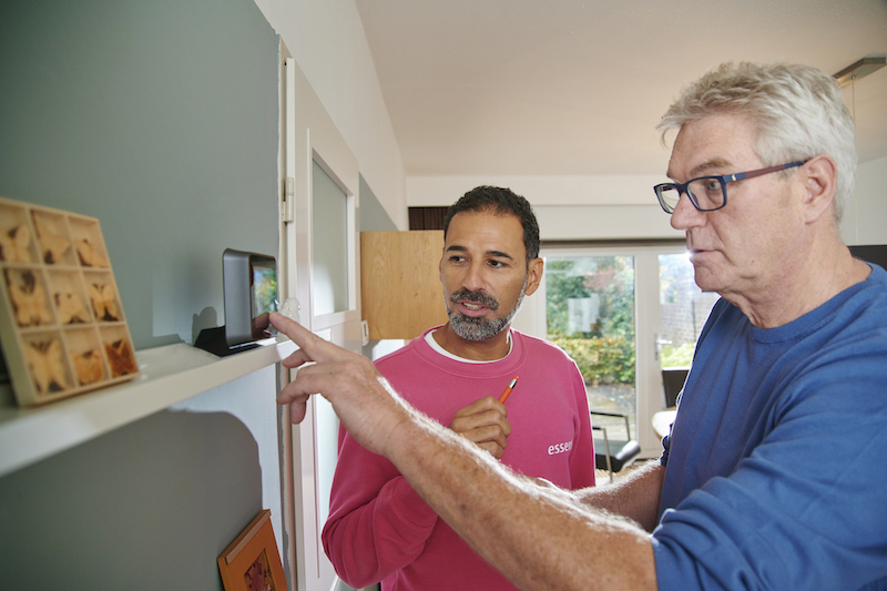 Man laat een thuisbatterij zien aan een andere man.