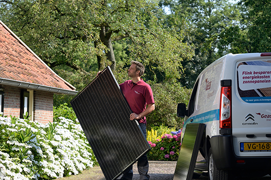 Een man heeft een zonnepaneel in zijn hand.