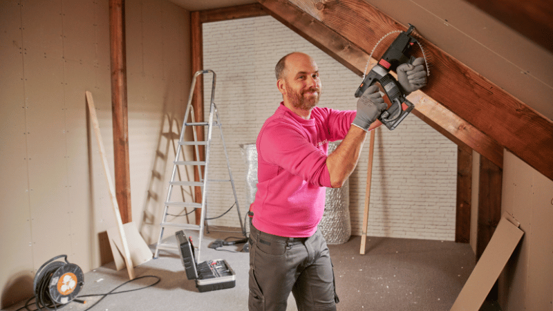 De monteur van Essent brengt isolatiemateriaal aan