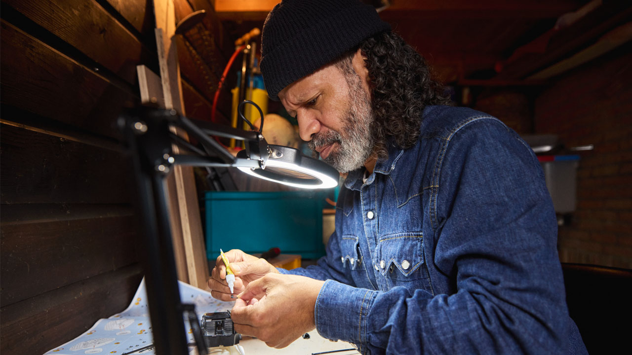 Man is bezig met hobby onder een lamp