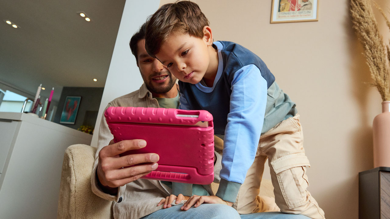 Een vader en kind kijken samen op een tabet