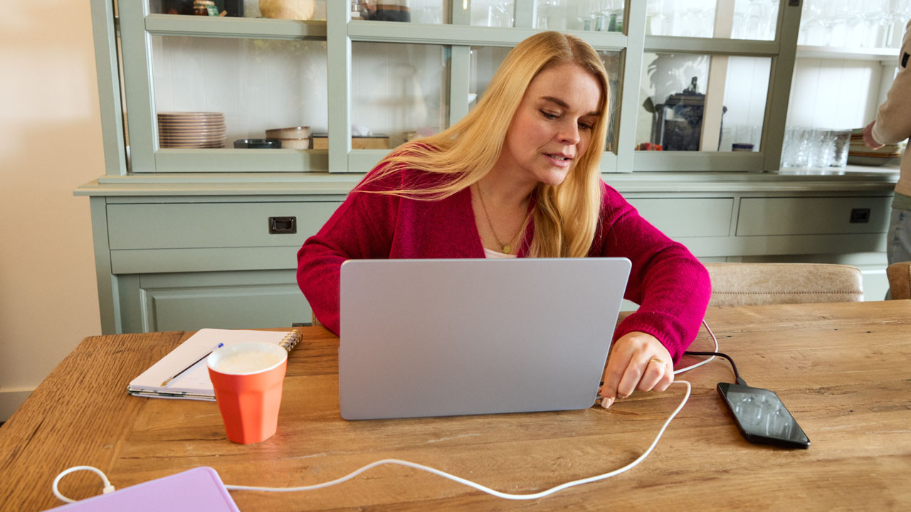 Een vrouw laadt haar laptop op