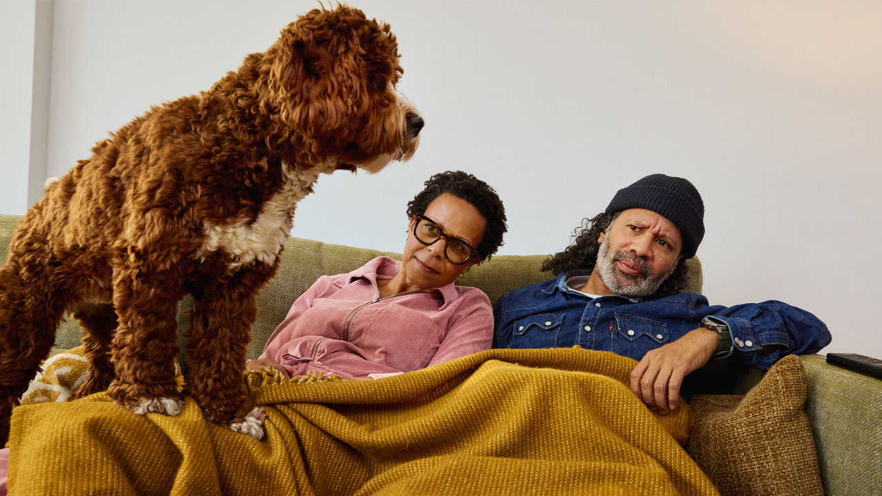 Twee mensen op de bank met een hond