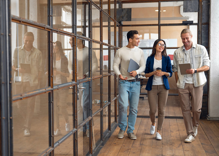 Drie mensen lopen naast elkaar op kantoor