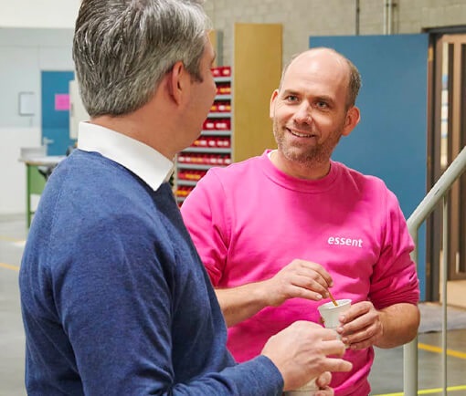 Voordelige zakelijke energie aanbiedingen bespreken met Essent medewerker aan koffieautomaat.