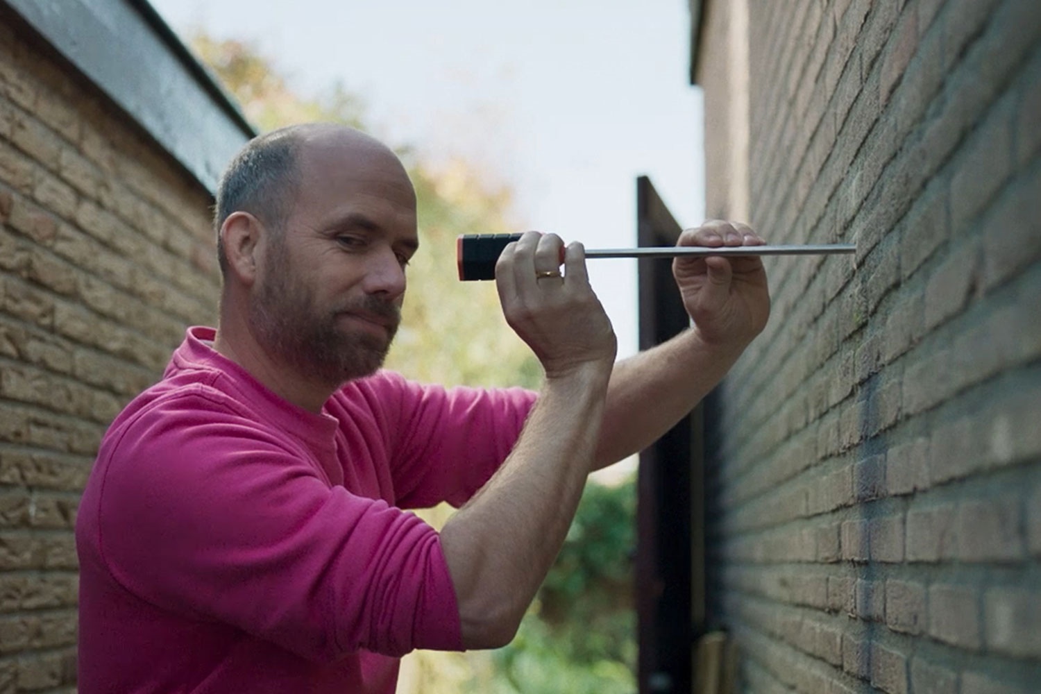 De monteur van Essent werkt aan de isolatie van een buitenmuur