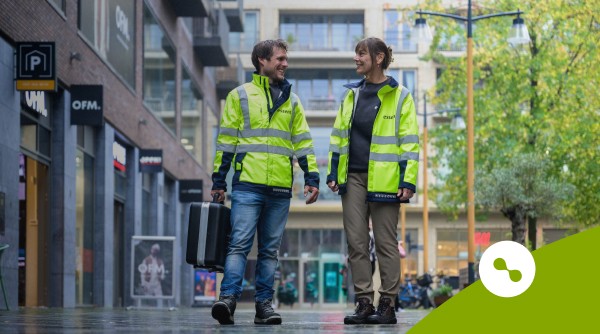 2 medewerkers van Essent Infrastructure Solutions wandelend in een winkelcentrum