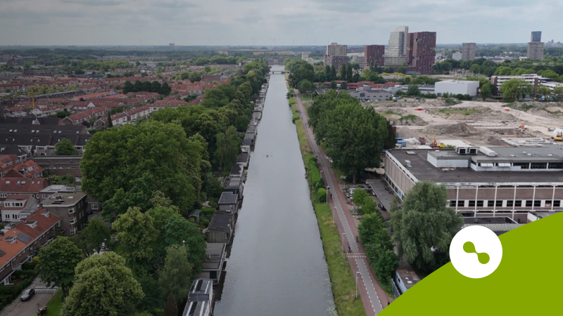 De Merwede met aan elke kant van de rivier bomen en gebouwen"