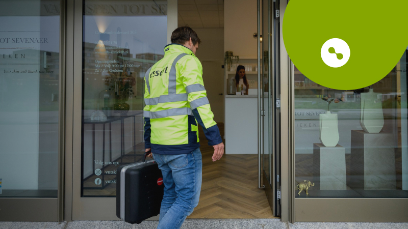 Essent-medewerker loopt met koffer winkel binnen