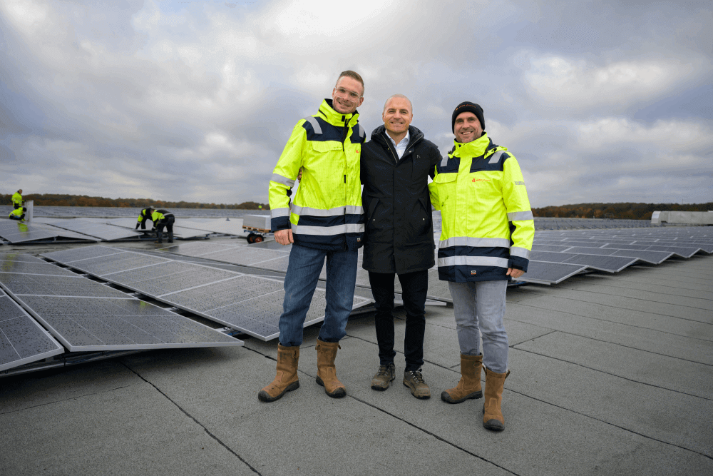 Aleksandar met monteurs op dak met zonnepanelen