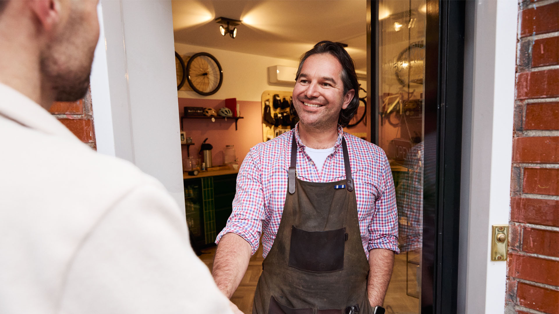 Een man verwelkomt de klant wanneer die binnenkomt.